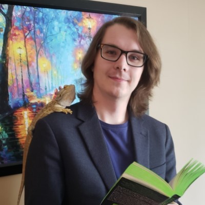 Daniel Brett with a lizard and book